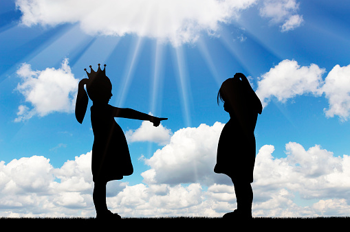 School bullying. Girl points finger at another crying girl. Concept of bullying among children and at school. Silhouette