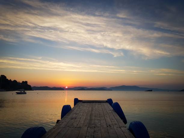istock Wooden pier over a lake under a cloudy sky at sunset 1435032478
