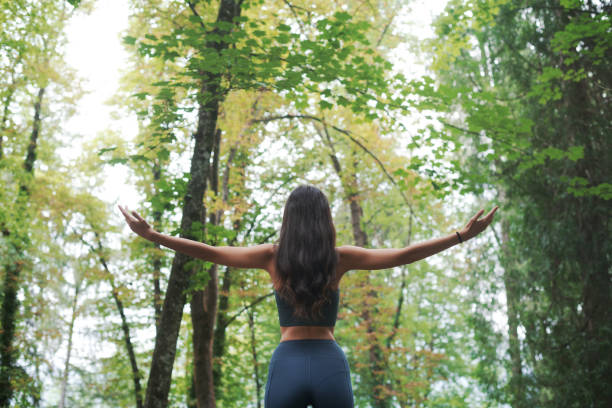 istock Woman with open arms in the forest 1435032648