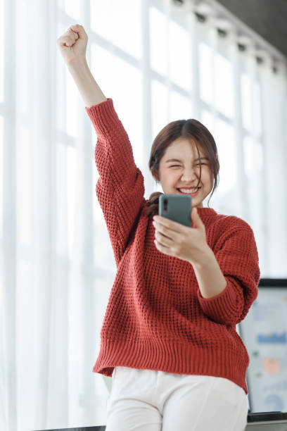 istock Confident Asian female office worker freelancer working in office, wearing red sweater, thai people. 1435034257
