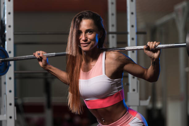 istock Young Woman Doing Exercise With Barbell Squat 1435035002