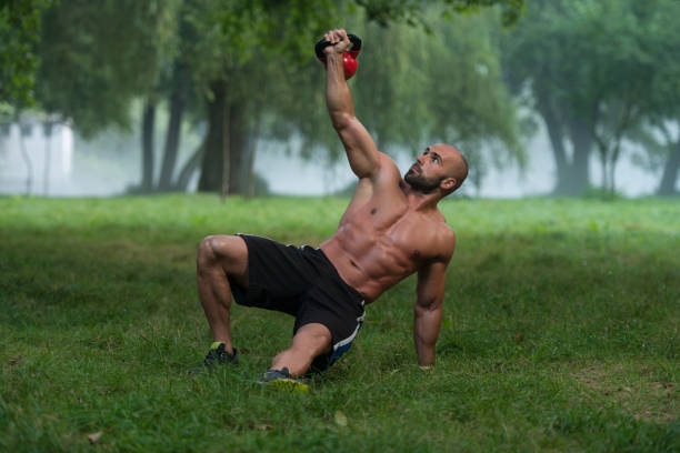 istock Kneeling Muscular Man Exercising With Kettlebells 1435035779
