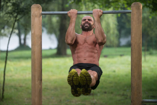 man doing chin ups a street workout - exercising men push ups muscular build imagens e fotografias de stock