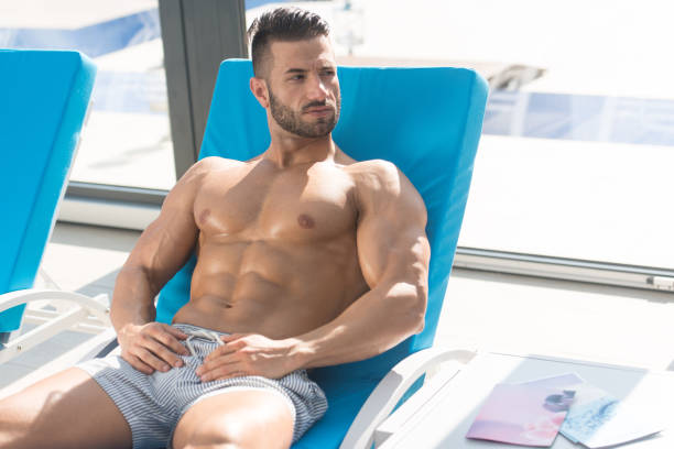 istock Man Resting On Sun Loungers By Swimming Pool 1435038169