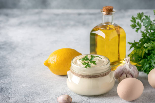 istock Aioli sauce with ingredients on a light gray grunge background. Side view, selective focus, copy space. Homemade mayonnaise. 1435039906