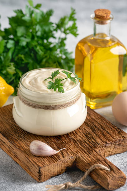 istock Aioli sauce with ingredients on a wooden cutting board. Side view, selective focus. Vertical image. 1435040022
