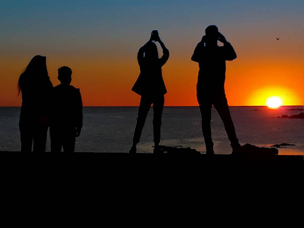 istock People taking photos of sunset 1435041236