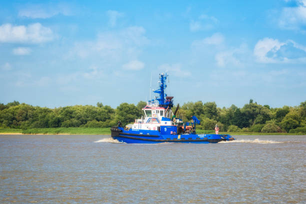 Stade, Germany – July 4, 2022: German tug boat BUGSIER 9 sailing downstream on Elbe river