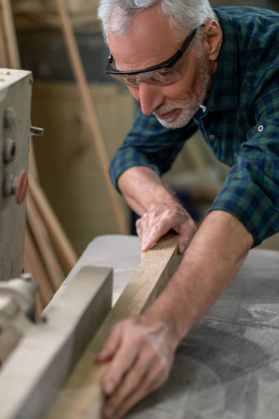 istock Mature carpenter working in a worshop and looking involved 1435046825