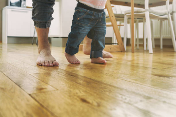 istock Father teaching baby to walk 1435047116