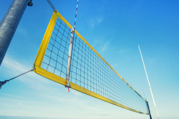 beach volley net with yellow frame fixed on metal pole on seashore - beach volleying ball playing imagens e fotografias de stock