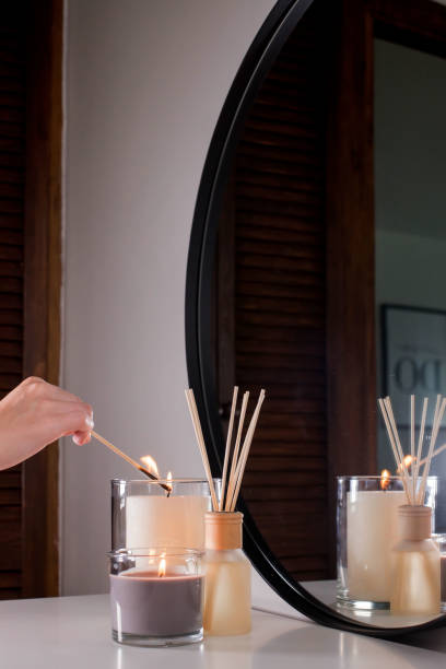 istock A woman's hand lights scented candles with a match. Romantic dinner. On a dark background 1435049994