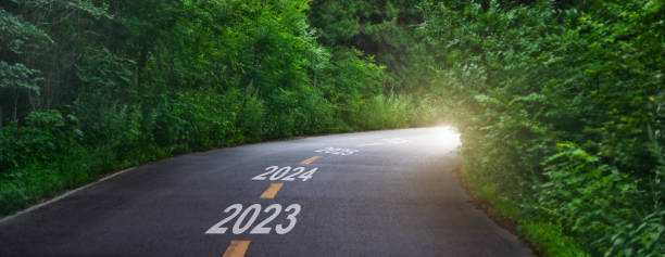 estrada curvilínea do asfalto de verão com números de 2023 a 2026 - diminishing perspective spring photography tree - fotografias e filmes do acervo