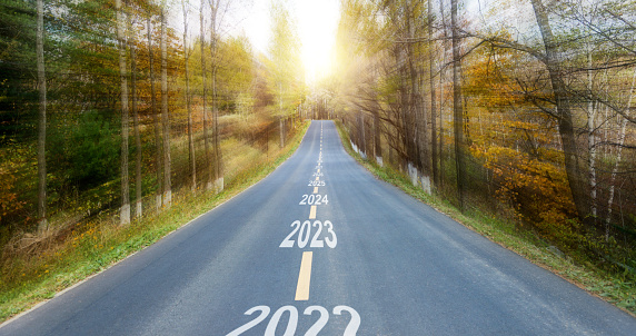 Scenic road with number 2023 and 2024 to 2030 through autumn trees