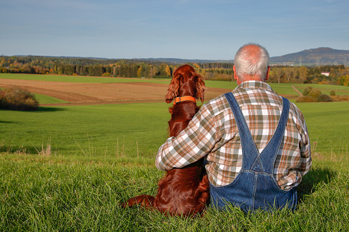 Portrait: senior man with his dog, rural Background