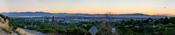 vista panorámica de árboles y edificios antes de la cordillera en antelope island al atardecer - isla antílope fotografías e imágenes de stock