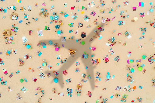 Airplane's shadow over a crowded beach