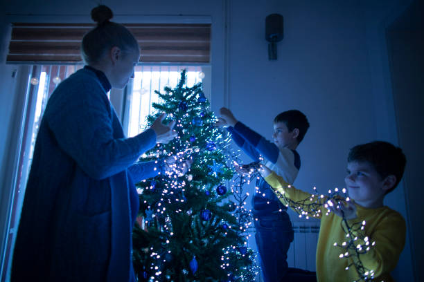 istock Two happy boys and their mom decorating a Christmas tree 1435054204