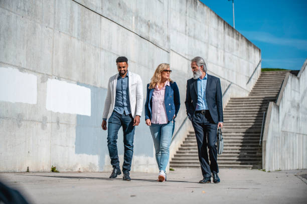 istock Three Business Workers Walking Together On The Sidewalk 1435054639