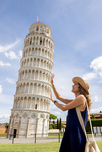Happy tourist holding the leaning tower of Pisa and smiling - travel concepts