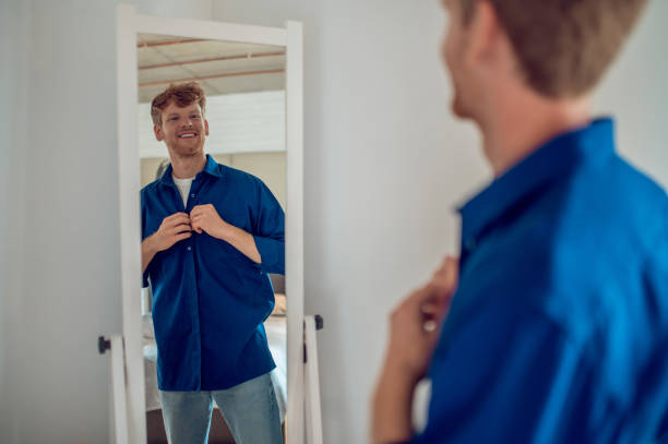 istock A confident young man getting dressed at the mirror 1435061726