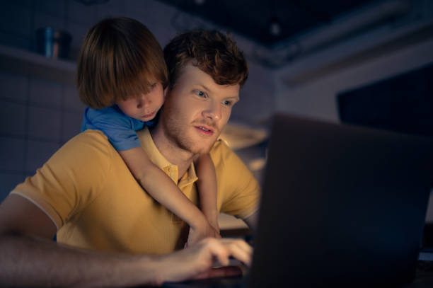 istock Ginger man nad his cute son watching something on internet in the evening 1435061793