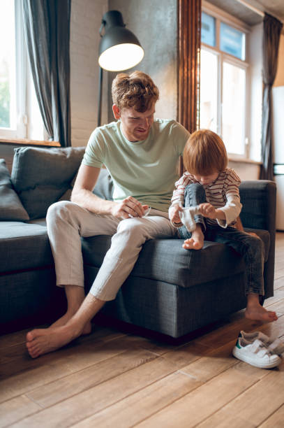 istock Father showing his little son how to get dressed 1435061892