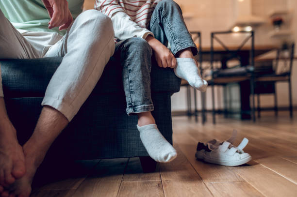 istock Little boy looking busy while getting on his shoes 1435061910