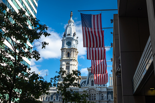 Philadelphia, USA - OCTOBER 12, 2018: The Philadelphia City Hall on a beautiful day with USA flags in the foreground.