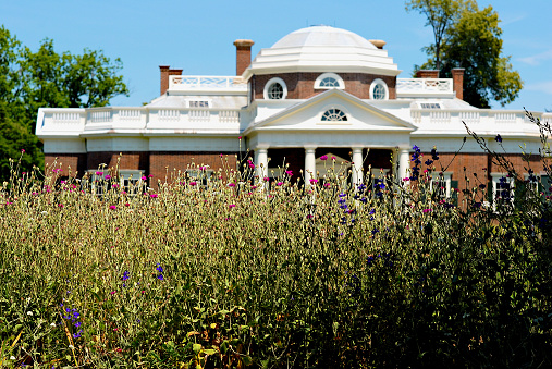 Charlottesville, Virginia, USA - June 17, 2012: Flowers partially obscure Thomas Jefferson’s home, Monticello, on a bright sunny day.