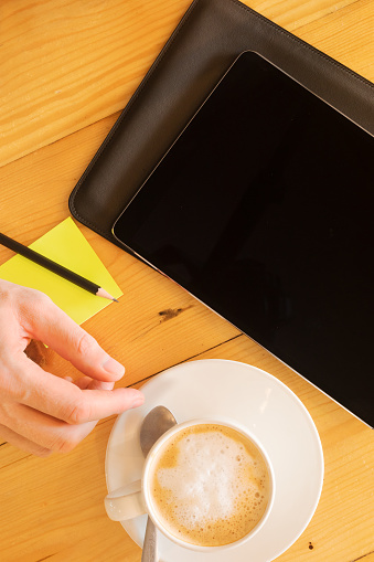 Male hand with coffee cup and digital tablet