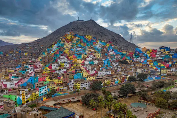 Photo of Shanty town in Lima, Peru. The once gray houses of the impoverished district of the Peruvian capital Lima shine in all colors. The campaign aims to attract tourists and improve the lives of residents.