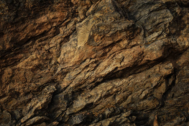 texture rocheuse brun rouge foncé orangé avec des fissures. gros plan.  fond de granit en pierre pour la conception. - igneous rock photos et images de collection