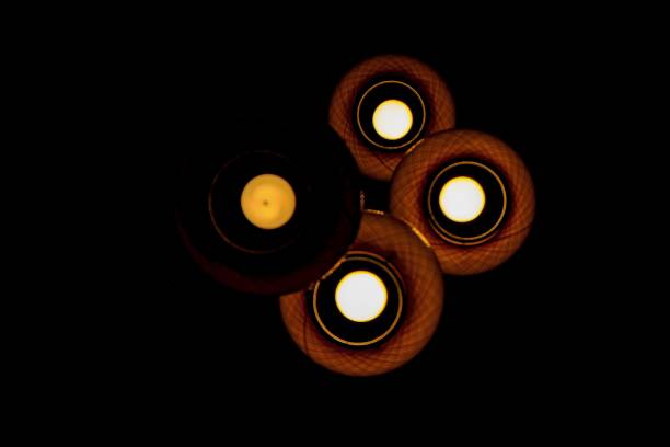 A low angle of four lamps with a dark background.