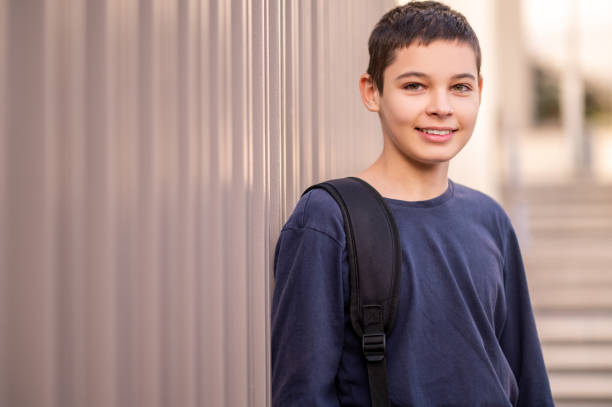 istock Adolescent with the backpack strap over the shoulder standing outdoors 1435071694