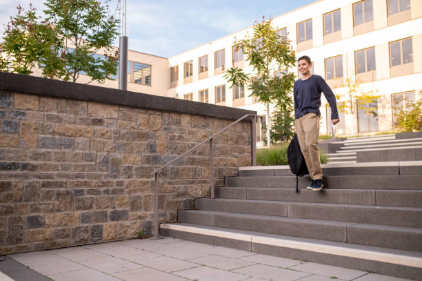 estudante alegre andando pelos degraus de concreto - staircase steps moving down student - fotografias e filmes do acervo