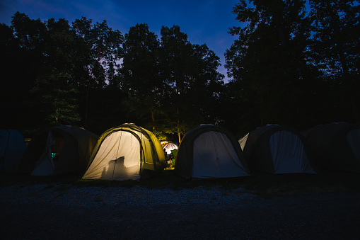 tent illuminated as the night falls over camp