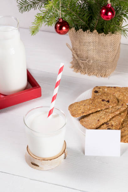 imagen de tradición navideña. leche para santa, galletas, ramas de abeto sobre mesa blanca. - milk milk bottle drinking straw cookie fotografías e imágenes de stock