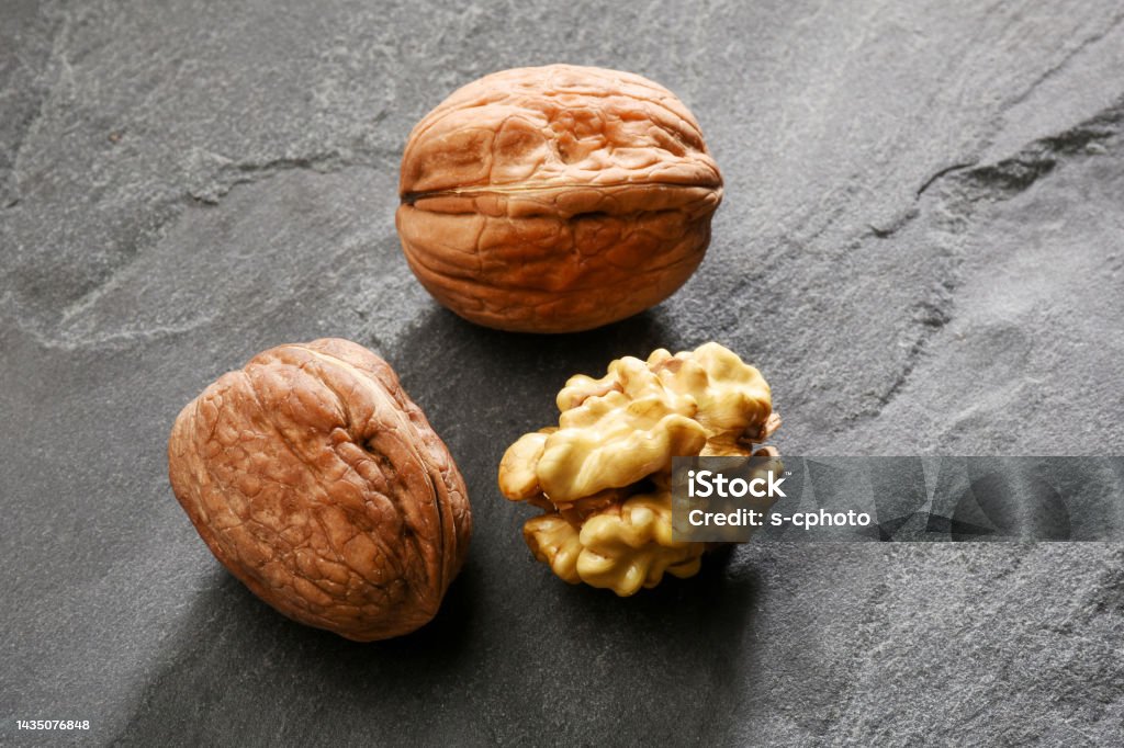 Walnuts on the gray granite stone background Close-up Stock Photo