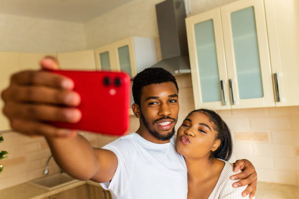 istock Cheerful multiethnic couple taking a selfie at the kitchen 1435077866