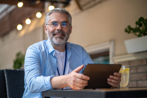istock Gray-haired mid aged man with a laptop 1435078623