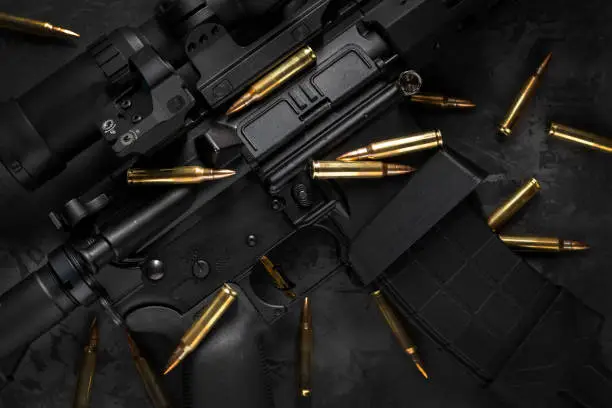 Photo of AR15 rifle with cartridges, flat lay composition