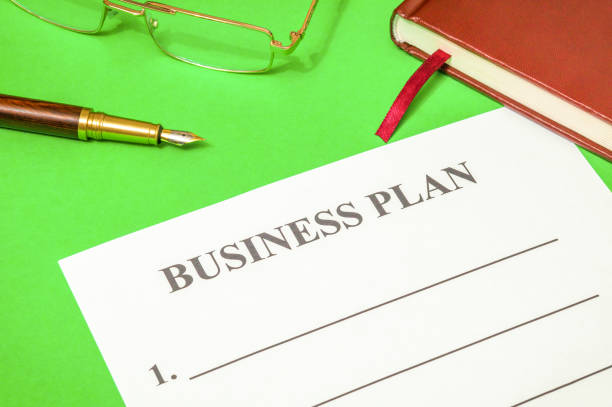 istock Blank of business plan and notepad on a green office desk 1435079734