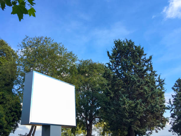 istock Billboard, empty billboard in the public park with trees and sky background (Screen has clipping path) 1435079871