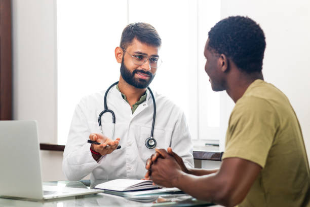 Indian doctor therapist in white coat consulting supporting patient in modern clinic hospital stock photo