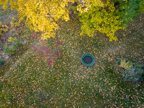 mini trampoline for fitness exercising and rebounding in a backyard, aerial view of fall scenery