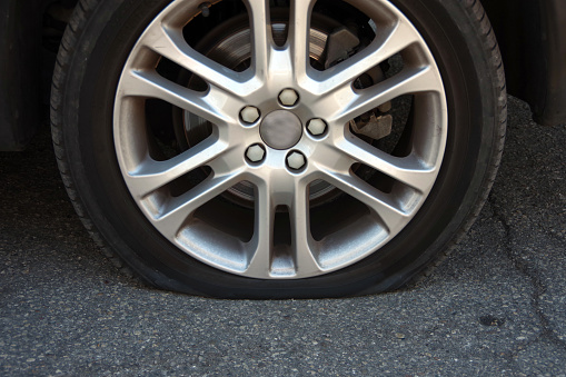 Low angle shot of a wheel on a open stretch of road.