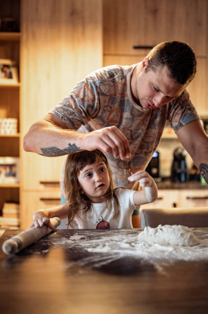 istock father and daughter cooking together in a real kitchen baking with dough. 1435085926