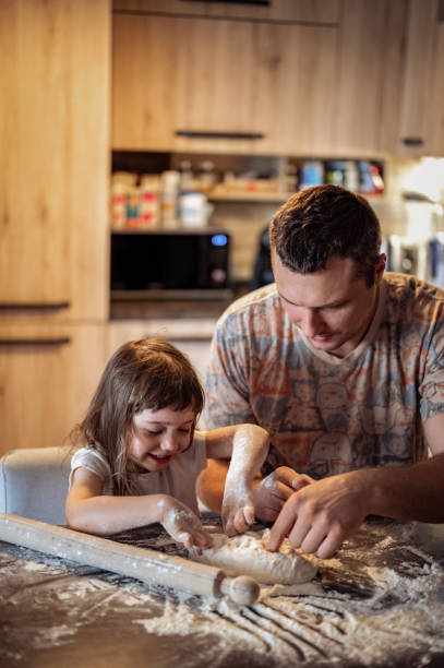 istock daughter baking with father. baking together in a real kitchen at home. 1435086681