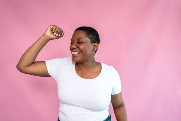 istock Happy mature woman dancing with a pink background 1435089639